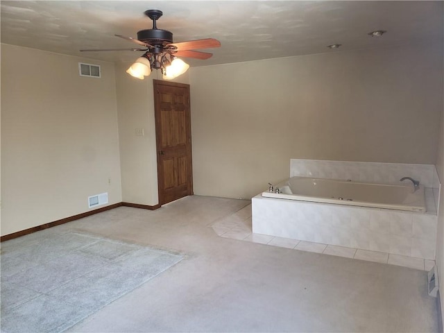 bathroom featuring ceiling fan and tiled bath