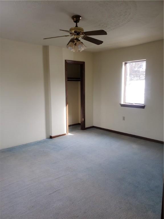 carpeted empty room with ceiling fan