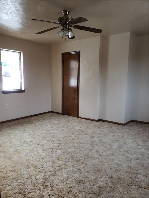 spare room featuring carpet floors and ceiling fan