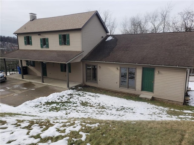 snow covered property with a carport