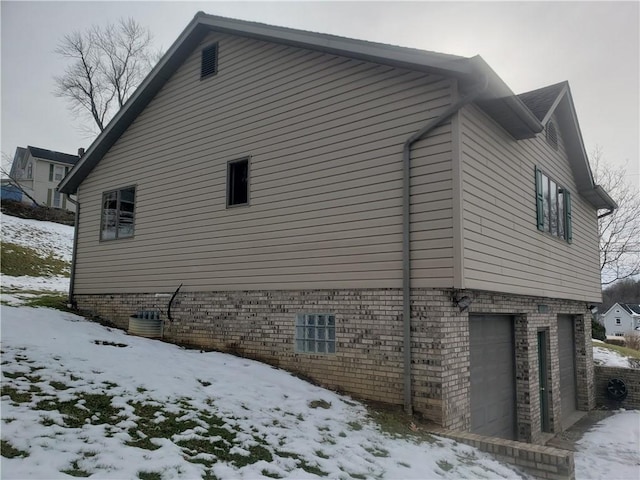 view of snowy exterior featuring a garage