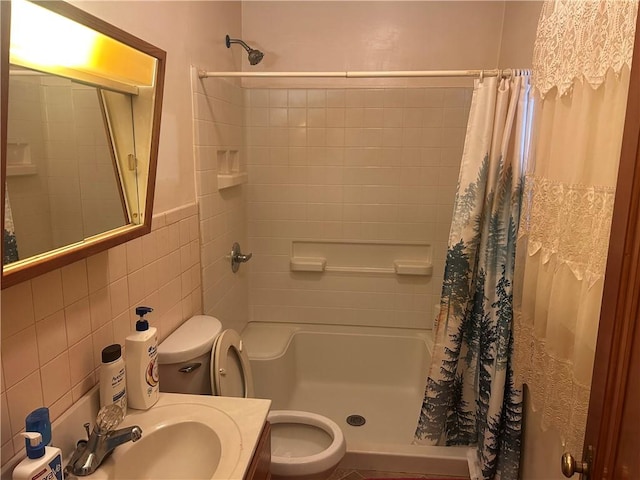 bathroom featuring vanity, toilet, curtained shower, and tile walls