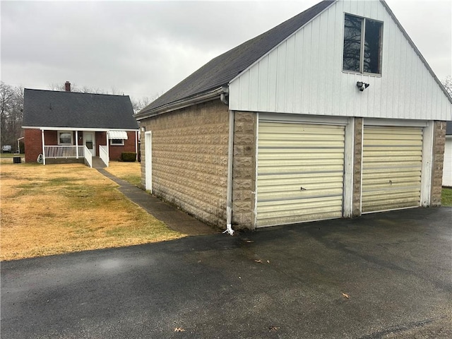 garage featuring a porch and a yard