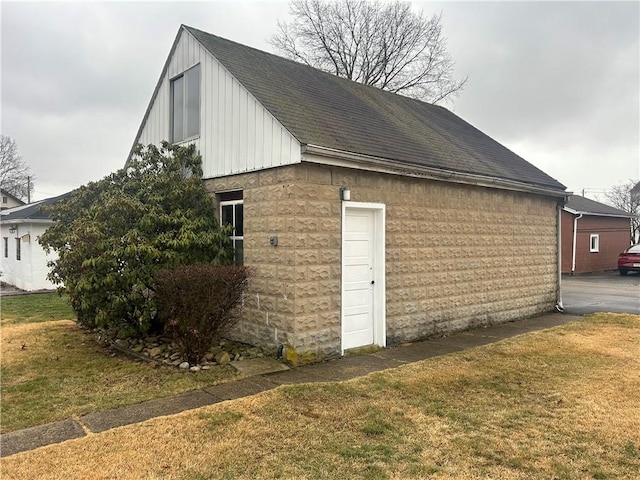 view of side of home with an outbuilding and a lawn