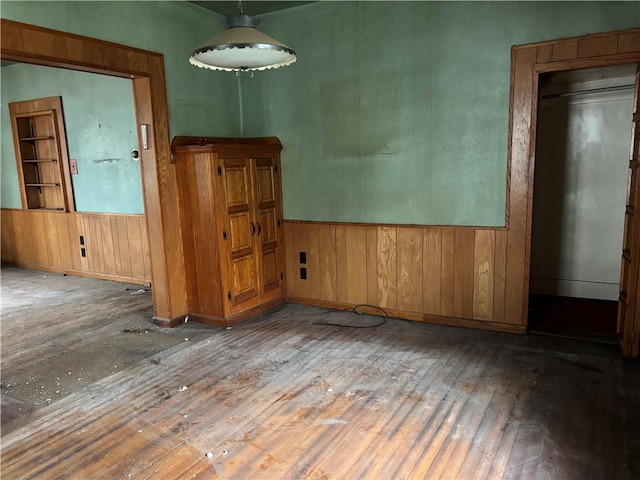 unfurnished room featuring hardwood / wood-style flooring and wood walls