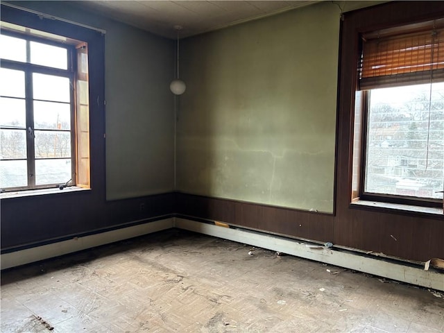 empty room with a baseboard radiator and plenty of natural light