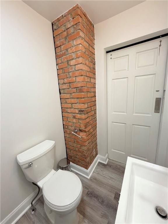 bathroom with hardwood / wood-style floors and toilet