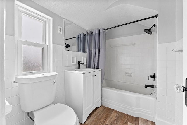 full bathroom featuring toilet, a textured ceiling, tile walls, vanity, and hardwood / wood-style flooring