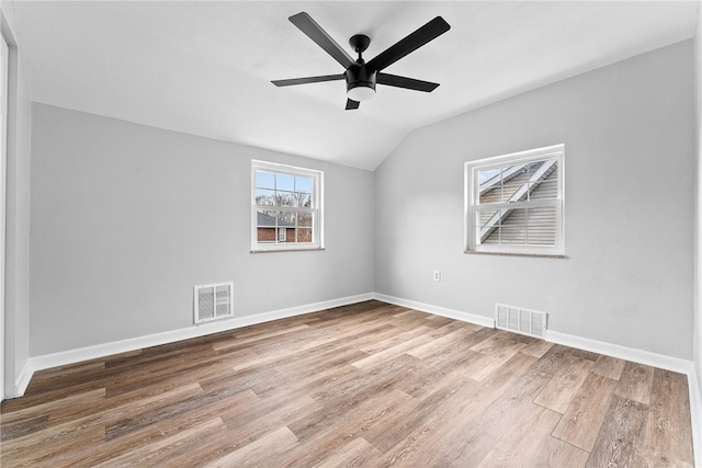 empty room featuring lofted ceiling, hardwood / wood-style floors, and ceiling fan