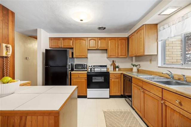 kitchen with sink, tile counters, and black appliances