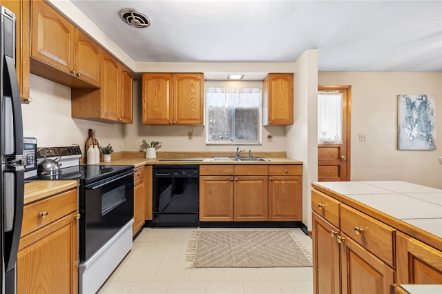 kitchen featuring sink, tile countertops, and black appliances