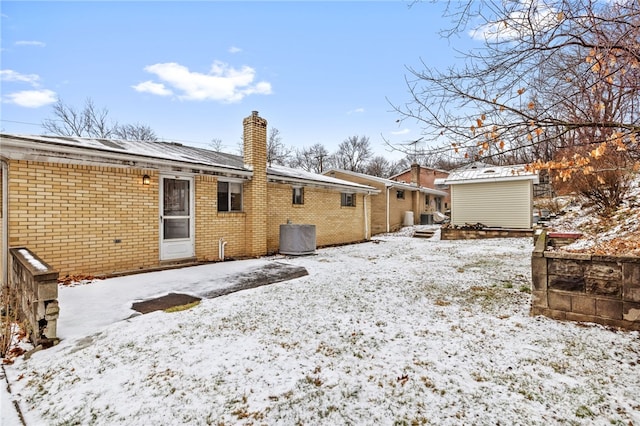 snow covered back of property with central AC unit