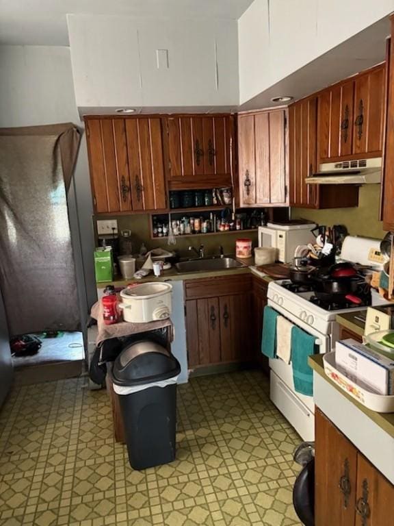 561/563 Sherman Ave, Sharon, PA 16146 - kitchen featuring white gas range, under cabinet range hood, light floors, and a sink
