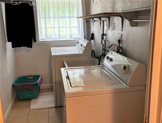 laundry room with washing machine and dryer and light tile patterned floors