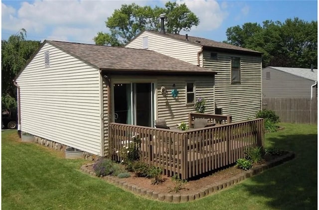 rear view of property featuring a yard and a wooden deck
