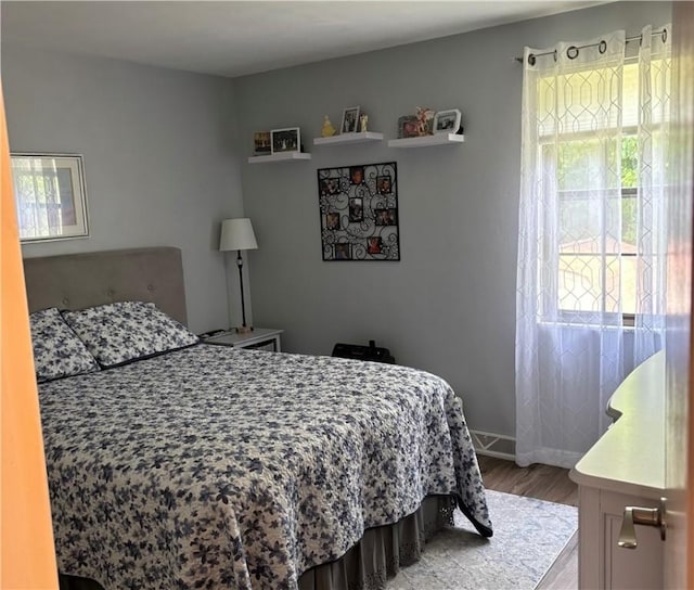 bedroom featuring multiple windows and hardwood / wood-style floors