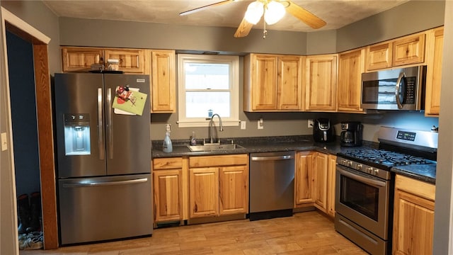 kitchen featuring sink, light hardwood / wood-style floors, ceiling fan, and appliances with stainless steel finishes