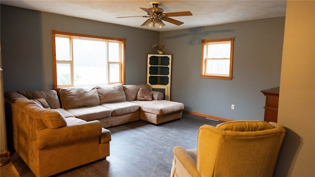 living room featuring dark wood-type flooring and ceiling fan