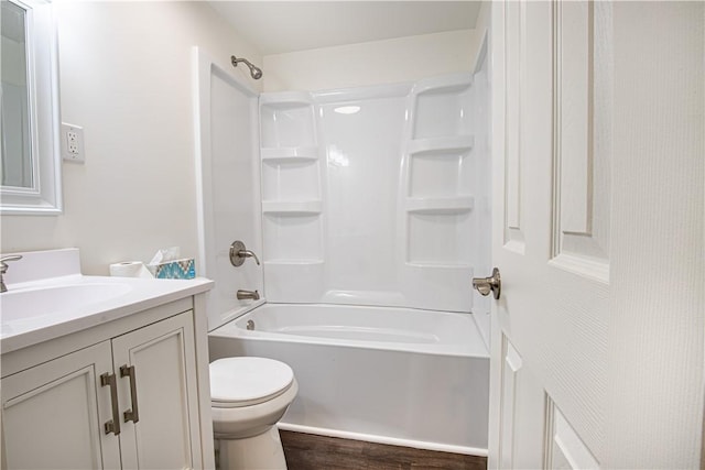 full bathroom featuring vanity, hardwood / wood-style floors, washtub / shower combination, and toilet