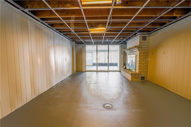 interior space with a brick fireplace and wooden walls