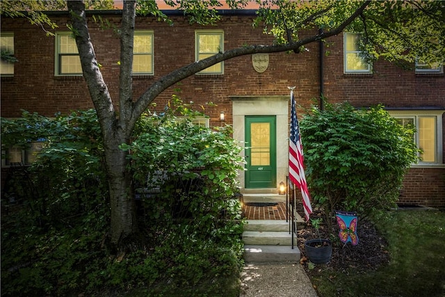 doorway to property featuring brick siding