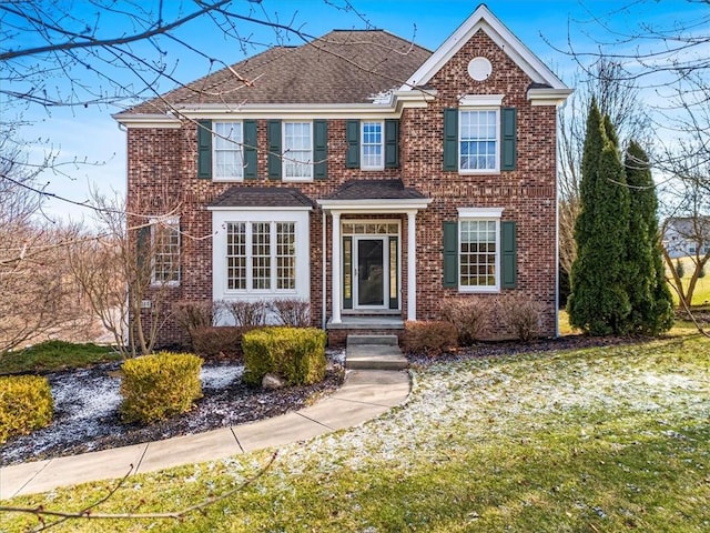 colonial home featuring a front lawn