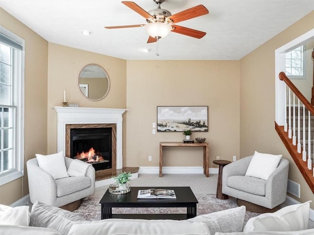 living room featuring ceiling fan, a fireplace, a healthy amount of sunlight, and carpet