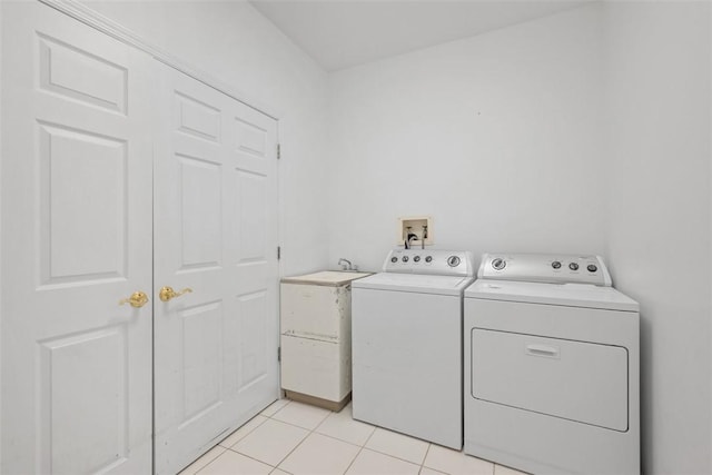 laundry room with sink, light tile patterned floors, and independent washer and dryer