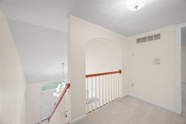 carpeted empty room featuring a chandelier