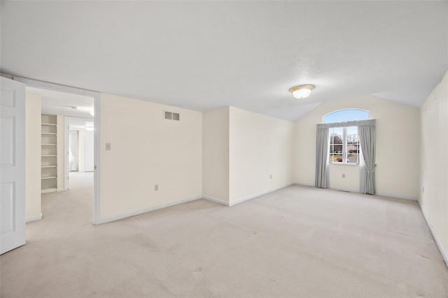 carpeted empty room featuring lofted ceiling