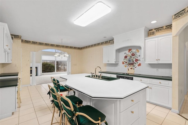 kitchen featuring pendant lighting, sink, a center island with sink, and white cabinets