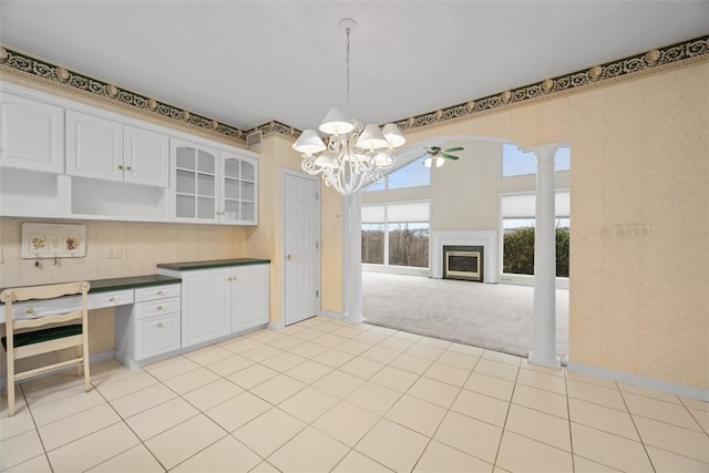 kitchen featuring pendant lighting, light carpet, decorative columns, and white cabinets