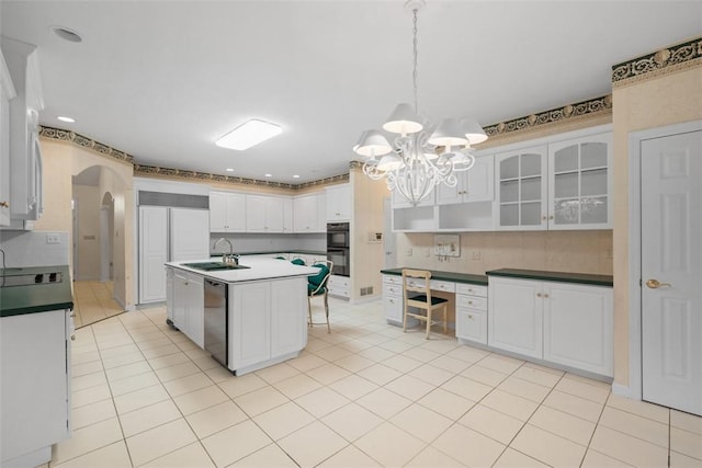 kitchen featuring sink, hanging light fixtures, dishwasher, a kitchen island with sink, and white cabinets