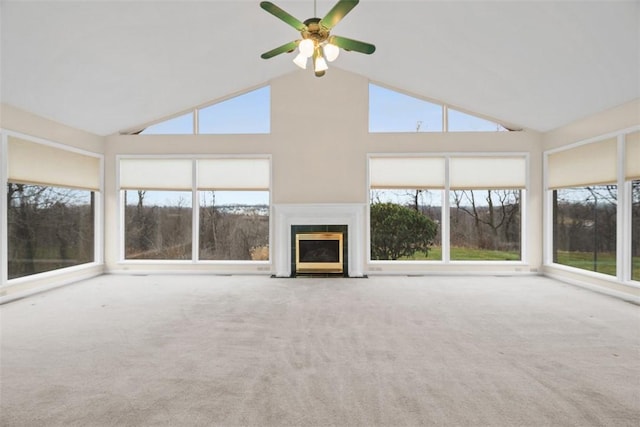 unfurnished living room with ceiling fan, carpet flooring, and high vaulted ceiling