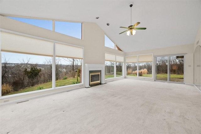 unfurnished living room with ceiling fan, high vaulted ceiling, and carpet