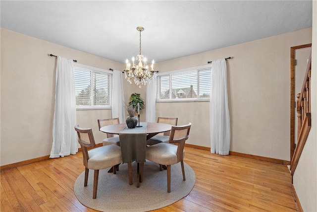 dining area featuring a wealth of natural light, light hardwood / wood-style floors, and a chandelier