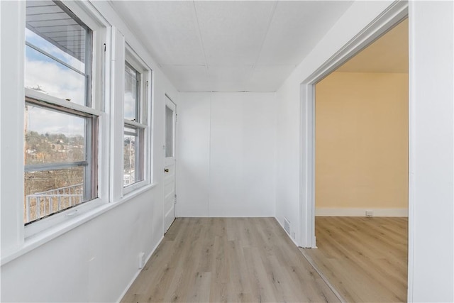 hall with baseboards and wood finished floors