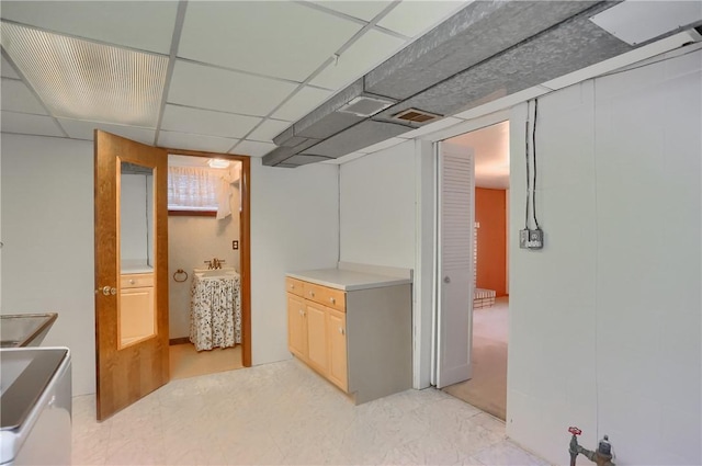 basement featuring a paneled ceiling and washer / clothes dryer