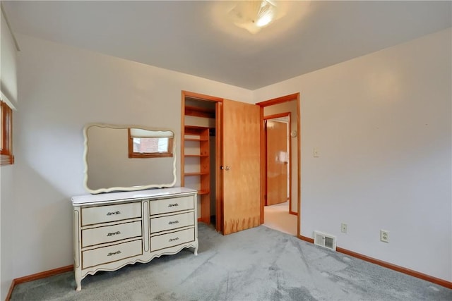 unfurnished bedroom with light carpet and a closet