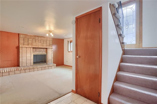 stairway featuring a brick fireplace