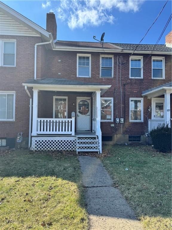 multi unit property featuring a front yard and a porch