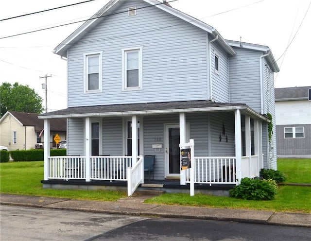 farmhouse featuring covered porch and a front yard