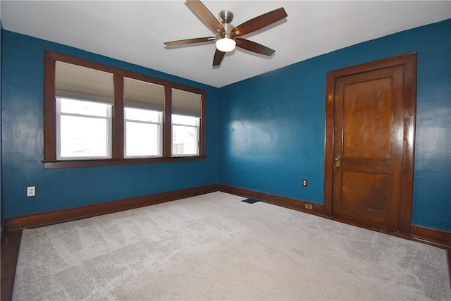 spare room with ceiling fan and light colored carpet