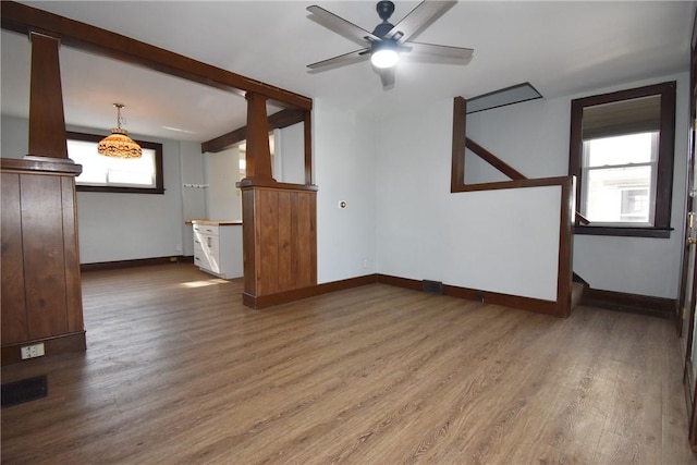 unfurnished living room with ceiling fan and wood-type flooring