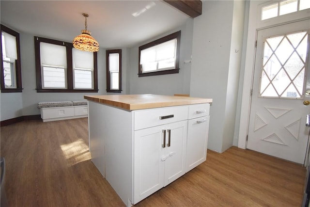 kitchen with light hardwood / wood-style floors, white cabinets, butcher block countertops, and pendant lighting