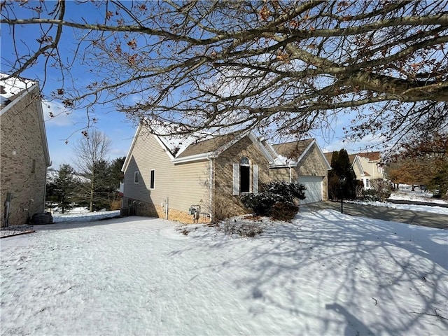 view of snowy exterior featuring a garage