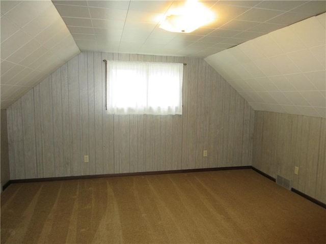 additional living space featuring dark carpet and vaulted ceiling