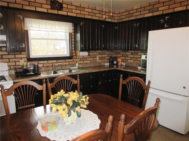 kitchen featuring sink, tasteful backsplash, and white refrigerator