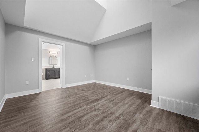 empty room with sink, high vaulted ceiling, and dark hardwood / wood-style flooring