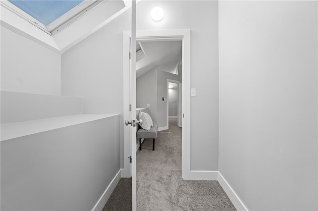 corridor featuring light carpet and a skylight